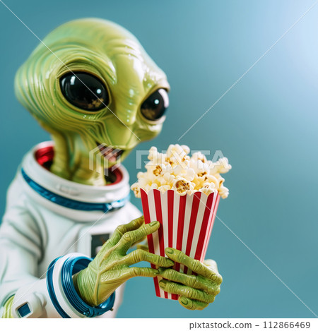 Green alien in space suit enjoying popcorn on a turquoise background 112866469