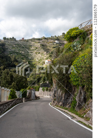 A crooked road at the Amalfi coast, lemon terraces above, Italy A crooked road at the Amalfi coast, lemon terraces above, Italy 112866579