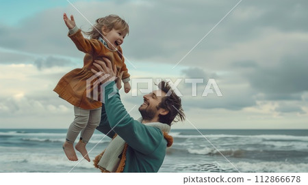 Joyful father lifting his child on a cloudy beach day. Candid family moment captured in a natural style. Perfect for sentimental projects. AI 112866678