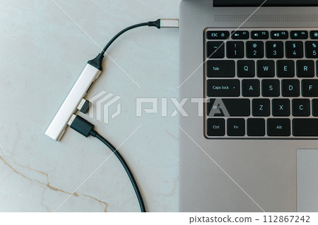 Close up of type c usb hub with multiple different ports connected to laptop 112867242