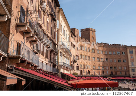 Old medieval brick houses surrounding the famous Piazza del Campo in the center of Siena Old medieval brick houses surrounding the famous Piazza del Campo in the center of Siena 112867467