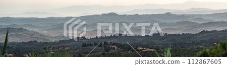 Typical Tuscan landscape with hills and cypresses in the very early morning near Montaione 112867605