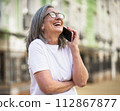 A woman wearing glasses is talking on her cell phone. 112867877