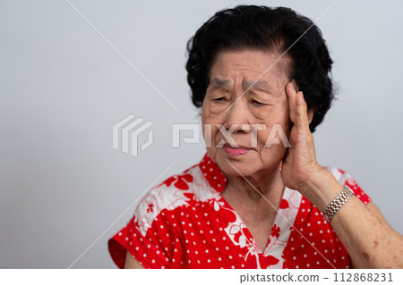 Depressed Asian senior woman lonely disappointed and lose memory in isolated white background. Portrait old woman ill sick depression disease feel sad and unhappy, dementia, health problems concept. Depressed Asian senior woman lonely disappointed and lose memory in isolated white background. Portrait old woman ill sick depression disease feel sad and unhappy, dementia, health problems concept. 112868231