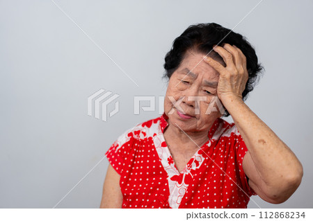 Depressed Asian senior woman lonely disappointed and lose memory in isolated white background. Portrait old woman ill sick depression disease feel sad and unhappy, dementia, health problems concept. 112868234