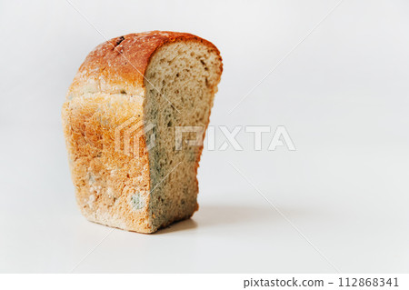 Cut piece of spoiled wheat bread with mold isolated on a white background Cut piece of spoiled wheat bread with mold isolated on a white background 112868341