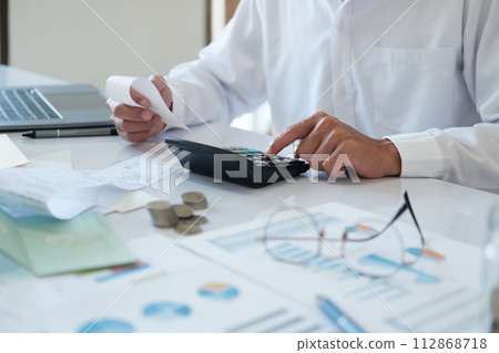 Accountants are using calculators to calculate budgets and investments. 112868718
