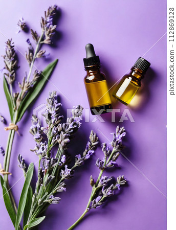 Lavender flowers and herbal essential oil on purple background. Relaxation, anti-stress. 112869128