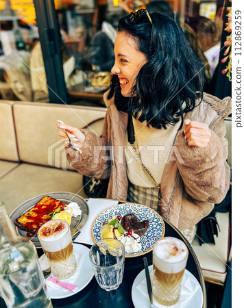 Coffee with ice cream and whipped cream on the table in Paris, France. French toast with ice cream and caramelized bananas on a plate. 112869259