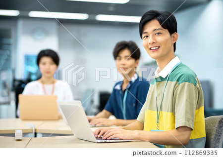 Young IT engineer working at desk in office Young IT engineer working at desk in office 112869335