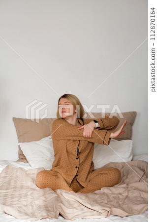 Woman stretching in pajamas with smartwatch Woman stretching in pajamas with smartwatch 112870164