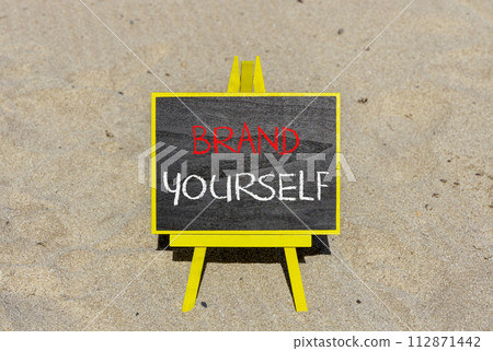 Brand yourself symbol. Concept words Brand yourself on beautiful black blackboard. Beautiful sand beach background. Business brand yourself concept. Copy space. Brand yourself symbol. Concept words Brand yourself on beautiful black blackboard. Beautiful sand beach background. Business brand yourself concept. Copy space. 112871442