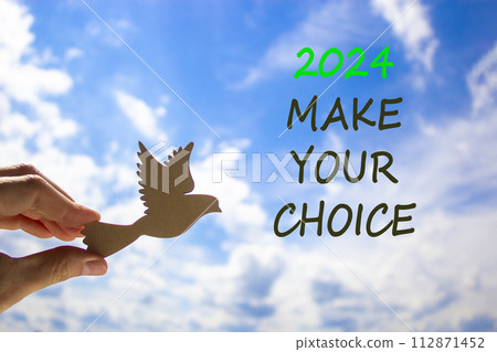 2024 Make your choice symbol. Concept words 2024 Make your choice. Beautiful blue sky cloud background. Voter hand with wooden bird. Business 2024 Make your choice concept. Copy space 2024 Make your choice symbol. Concept words 2024 Make your choice. Beautiful blue sky cloud background. Voter hand with wooden bird. Business 2024 Make your choice concept. Copy space 112871452
