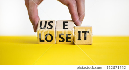 You use or lose it symbol. Concept word Use It or lose it on wooden cubes. Beautiful yellow table white background. Businessman hand. Business and you use or lose it concept. Copy space. You use or lose it symbol. Concept word Use It or lose it on wooden cubes. Beautiful yellow table white background. Businessman hand. Business and you use or lose it concept. Copy space. 112871532