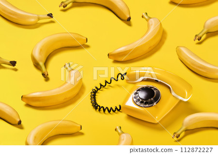 Creative pattern bananas and old yellow phone with hard shadows pattern on yellow background flat lay bananaphone Creative pattern bananas and old yellow phone with hard shadows pattern on yellow background flat lay bananaphone 112872227