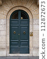 doors of Rome. Classic old wooden door in a public place on a city street or in an urban environment 112872673