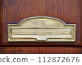 mailbox on the door. Wooden vintage door with golden postbox, letters and newspapers in mailbox. Concept 112872676