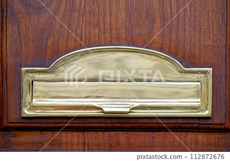 mailbox on the door. Wooden vintage door with golden postbox, letters and newspapers in mailbox. Concept 112872676