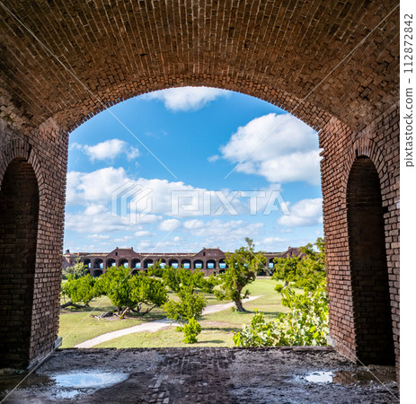 View through an open archway in Fort Jefferson on Dry Tortugas National Park with a the open courtyard a parade ground in the distance. View through an open archway in Fort Jefferson on Dry Tortugas National Park with a the open courtyard a parade ground in the distance. 112872842