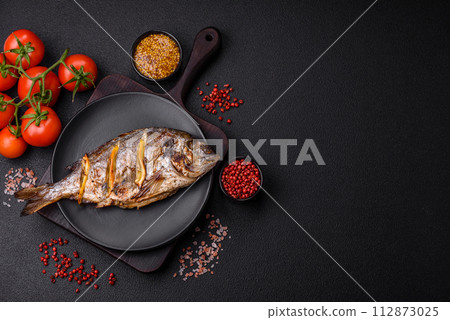 Delicious dorado baked on the grill with salt, spices and herbs 112873025