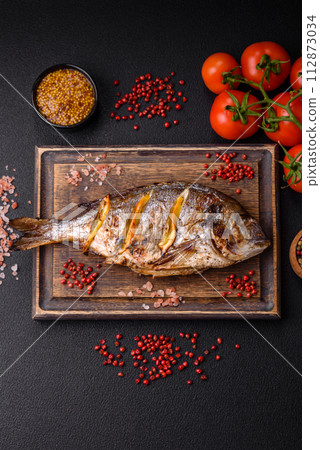 Delicious dorado baked on the grill with salt, spices and herbs 112873034