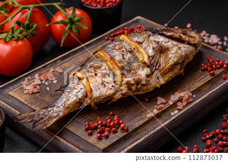 Delicious dorado baked on the grill with salt, spices and herbs 112873037