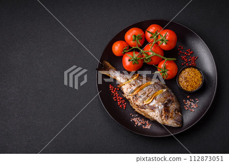 Delicious dorado baked on the grill with salt, spices and herbs Delicious dorado baked on the grill with salt, spices and herbs 112873051