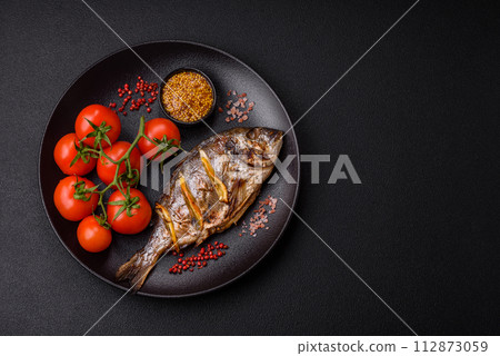 Delicious dorado baked on the grill with salt, spices and herbs Delicious dorado baked on the grill with salt, spices and herbs 112873059