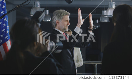 President of the USA waves his hand and poses for media cameras President of the USA waves his hand and poses for media cameras 112873144