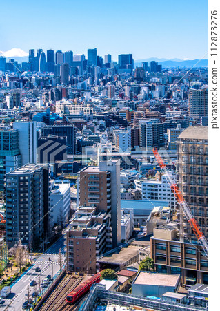 New view of Tokyo cityscape in Japan. Mt.Fuji and Shinjuku. In the foreground is the new Tokyo Metro Marunouchi Line 2000 series train running on the ground. New view of Tokyo cityscape in Japan. Mt.Fuji and Shinjuku. In the foreground is the new Tokyo Metro Marunouchi Line 2000 series train running on the ground. 112873276