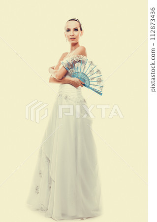 Full length bride in wedding gown holds fan Full length bride in wedding gown holds fan 112873436