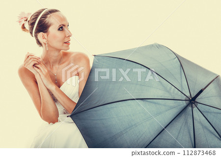 Full length bride in wedding gown holds umbrella Full length bride in wedding gown holds umbrella 112873468