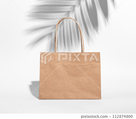 Craft brown paper bag, shopping packet, leaf shadow Craft brown paper bag, shopping packet, leaf shadow 112874800