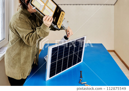 Outdoor led solar street lights during Installation, screw fixing, connection to mounting bracket. 112875549