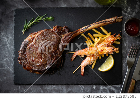 tomawahk steak on black stone board 112875595