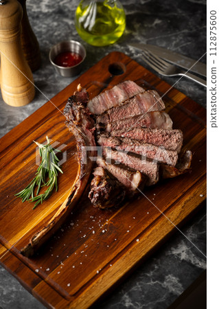 sliced tomahawk steak on wooden board sliced tomahawk steak on wooden board 112875600