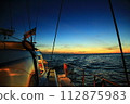 Sunset seen from the deck of a boat 112875983