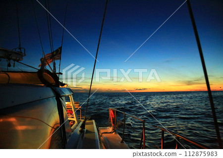 Sunset seen from the deck of a boat 112875983
