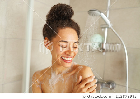 a woman is taking a shower in a bathroom and smiling a woman is taking a shower in a bathroom and smiling 112878982