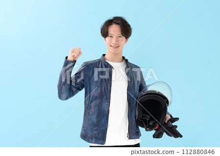 一個男人拿著頭盔,做拳頭泵 一個男人拿著頭盔,做拳頭泵 112880846