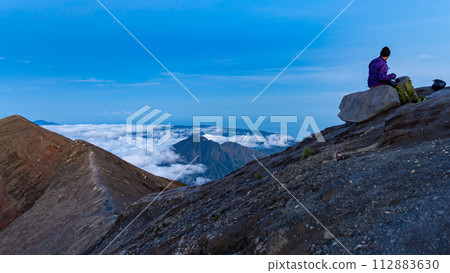 Sunrise at the top of the Ijen volcano. Panoramic view of East Java, Indonesia. The background of the natural landscape. Sunrise at the top of the Ijen volcano. Panoramic view of East Java, Indonesia. The background of the natural landscape. 112883630