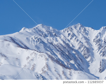 Distant view of the snow-capped Northern Alps seen from Hakuba Village in winter 112885037