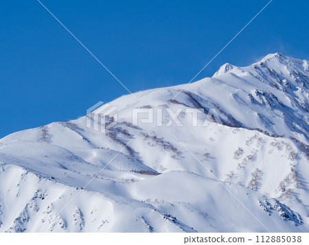 Distant view of the snow-capped Northern Alps seen from Hakuba Village in winter 112885038