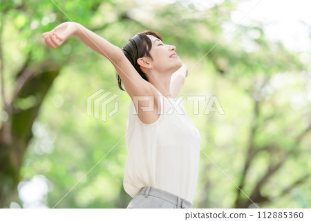 Woman stretching, deep breathing, fresh greenery Woman stretching, deep breathing, fresh greenery 112885360