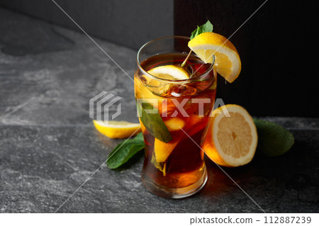 Iced tea or a summer refreshing drink with ice, mint, and lemon. 112887239