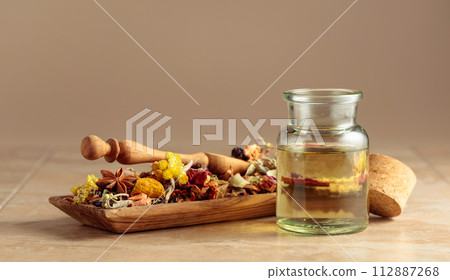 Essential oil or herbal tincture in a  small glass bottle. 112887268