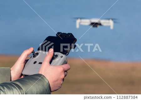 woman hands piloting a drone 112887384
