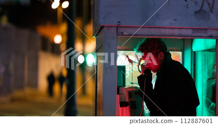 A man is talking on a phone at noir style in booth A man is talking on a phone at noir style in booth 112887601