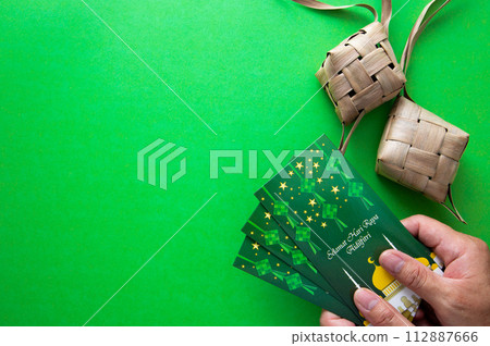 Hand holding Money envelop for muslim Eid celebration. Hand holding Money envelop for muslim Eid celebration. 112887666