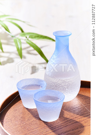 Transparent sake bottle and choko sake bottle where light shines through - Japanese sake image 112887727
